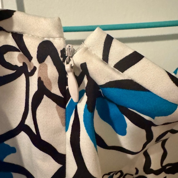 Teal blouse with teal and black highlights on a white skirt. - Picture 12 of 15